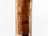 a person that is standing next to a tall piece of wood