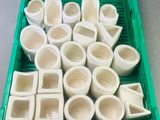 une caisse verte remplie de bols et de tasses blancs