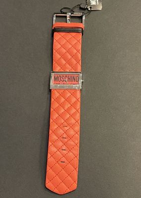 an orange watch strap with a metal clasp on a gray surface