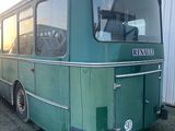 un bus vert garé devant un immeuble