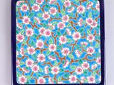 assiette à fleurs bleues et roses sur fond blanc