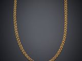 a gold chain necklace on a black background