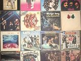 many different album covers on the wall of a room