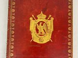 un vieux livre rouge orné d'un emblème doré
