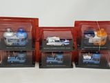 three boxed boxed toy vehicles in plastic cases on a white surface