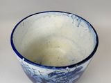 a blue and white bowl sitting on a white surface