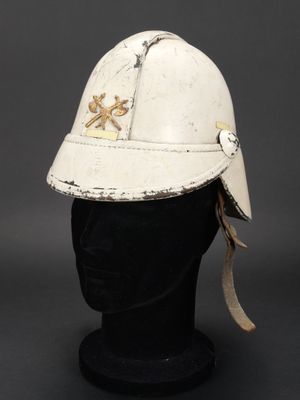 un vieux casque blanc posé sur la tête d'un mannequin, sur une surface noire