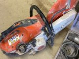 two chainsaws sitting on the floor next to a tool box