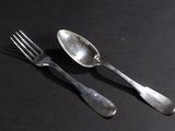 two spoons and a fork on a black surface