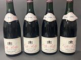 quatre bouteilles de vin sont alignées sur une table