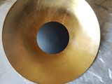 a gold plate with a black hole in it on the floor