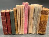 several old books are lined up in a row on a table