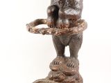a statue of a bear that is on a stool