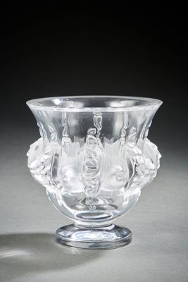 a glass vase with flowers on it sitting on a table