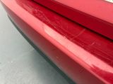 a close up of a red car ' s front bumper