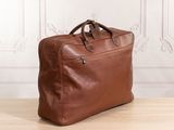 a brown leather briefcase sitting on top of a wooden table