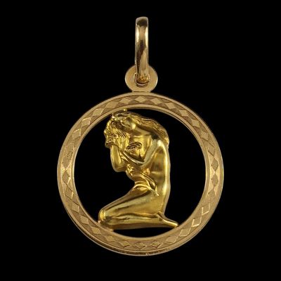un gros plan d'un pendentif plaqué or représentant un homme à l'intérieur d'un cercle