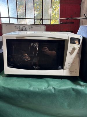 a microwave sitting on a table with a green table cloth