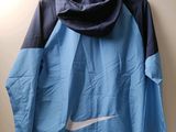 blue and black nike jacket hanging on a hanger on a wall