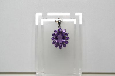 un gros plan d'un collier orné d'une fleur violette