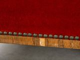 an image of a red velvet upholstered chair with metal studding