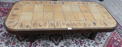 une table en bois avec un plateau en carrelage, posée sur un tapis
