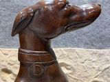 statue of a dog with a collar sitting on a table