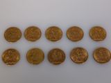 a group of gold coins sitting on top of a white surface