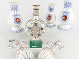 five vases and a bottle of liquor on a table