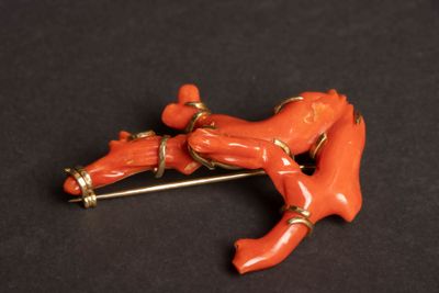 une image représentant une broche sur laquelle est représentée une femme allongée