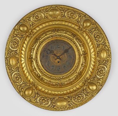 une image représentant une assiette en or avec une horloge au centre