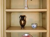 a shelf that has a vase and a plate on it
