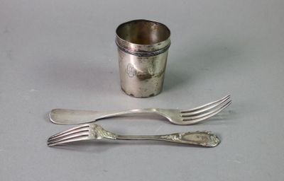 two forks and a silver cup on a table