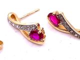 une paire de boucles d'oreilles en rubis et diamants sur fond blanc