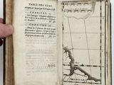 someone is holding a book with a map inside of it