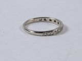 a close up of a diamond ring on a white surface