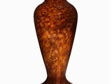 a brown vase that is sitting on a white surface