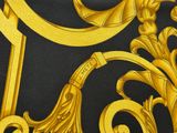 yellow and black neck tie with a gold design on it