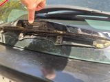 a person pointing at a broken windshield on a car