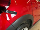 a close up of a red car with a sticker on it