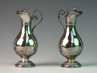 two silver vases sitting next to each other on a table