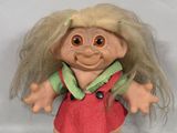 a troll doll with blonde hair wearing a red dress