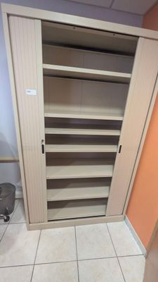un placard dans un coin d'une pièce, dont la porte est ouverte