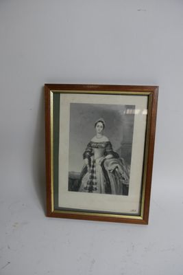 une vieille photo d'une femme en robe est accrochée au mur