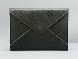 Une enveloppe noire est posée sur une table blanche.