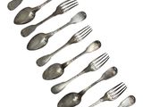 a lot of forks and spoons that are arranged in a row