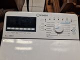 a white washing machine sitting on a tiled floor