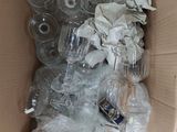 a cardboard box full of empty wine glasses and other items