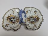 two plates with blue and white designs on them sitting on a table