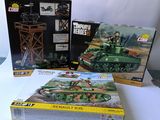 trois boîtes de véhicules militaires lego posées sur une table
